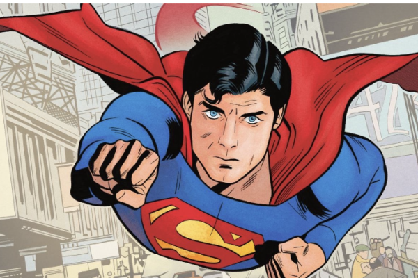 Image of superman, wearing a blue costume with red cape flowing towards the back of the image, his right arm is pointed forward. Superman flying towards the viewer, a gray-toned cityscape in perspective is behind him.